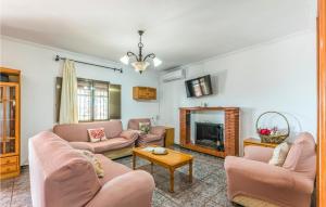 sala de estar con muebles de color rosa y chimenea en Nice Home In Montoro With Kitchenette, en Montoro