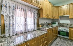 a kitchen with wooden cabinets and a sink at 3 Bedroom Beautiful Home In Montoro in Montoro
