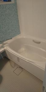 a white bath tub sitting in a bathroom at Guest House Shiraishi in Kasaoka