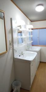 W łazience znajduje się biała umywalka i lustro. w obiekcie Guest House Shiraishi w mieście Kasaoka