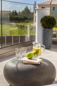 a table with two glasses and a drink and a lime at Artemon New Luxury Villa in Skala Kefalonias