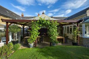 a wooden pergola in the yard of a house at The Ollerod in Beaminster