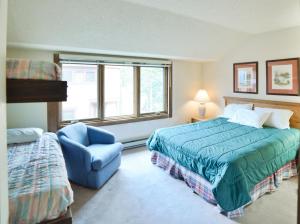 um quarto com uma cama e uma cadeira azul em 200_Primrose em Breckenridge