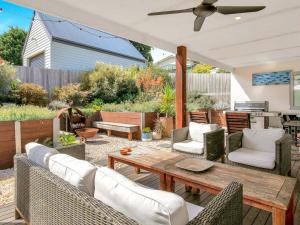 a patio with a wooden table and chairs at Blue Waves in Smiths Beach