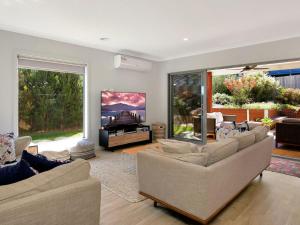 a living room with couches and a flat screen tv at Blue Waves in Smiths Beach