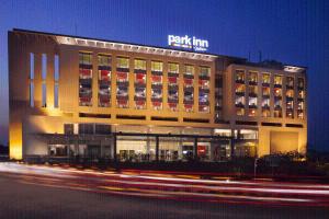 a building with a sign on top of it at night at Park Inn By Radisson Gurgaon Bilaspur in Manesar