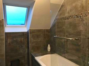 une salle de bain avec une baignoire et une fenêtre dans l'établissement L’Oree de la Bouvaque, à Abbeville