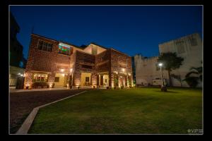 a large brick building with a green yard at night at A Heritage Homestay in Jodhpur
