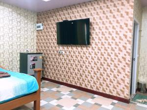 a bedroom with a tv on the wall at ริมบึงสวนพริกรีสอร์ท in Phra Nakhon Si Ayutthaya