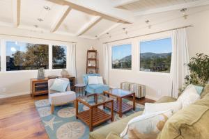 een woonkamer met een bank, stoelen en ramen bij Ocean & Mountain View Home - Walk to Trails Beach Family Activities in Montara