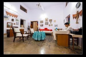 a man sitting at a table in a room at A Heritage Homestay in Jodhpur