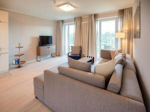 ein Wohnzimmer mit einem Sofa und einem TV in der Unterkunft Dünenresidenz Prora - Ferienwohnung mit Meerblick, 2 Schlafzimmern und Balkon NP-311 in Binz