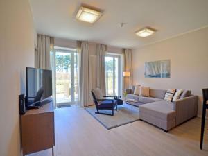 ein Wohnzimmer mit Couch und Fernseher in der Unterkunft Dünenresidenz Prora - Ferienwohnung mit Meerblick und 1 Schlafzimmer und Terrasse NP-704 in Binz
