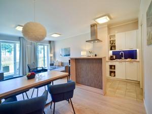 eine Küche und ein Wohnzimmer mit Tisch und Stühlen in der Unterkunft Dünenresidenz Prora - Ferienwohnung mit Meerblick und 1 Schlafzimmer und Terrasse NP-704 in Binz