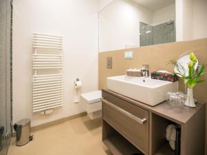 ein Badezimmer mit Waschbecken, Toilette und Spiegel in der Unterkunft Dünenresidenz Prora - Ferienwohnung mit Meerblick und 1 Schlafzimmer und Terrasse NP-704 in Binz