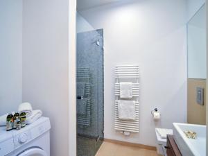 ein Bad mit einer Dusche und einer Waschmaschine in der Unterkunft Dünenresidenz Prora - Ferienwohnung mit Meerblick und 1 Schlafzimmer und Terrasse NP-704 in Binz + 4 Fotos