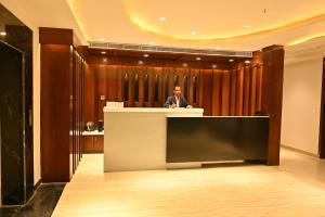 a man standing at a podium in a lobby at Hotel Aakriti Clarks Inn Express in Bareilly