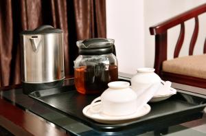 a table with a coffee maker and tea pots on it at Puthens Capitol Inn in Cochin