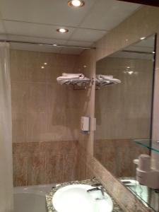 a bathroom with a bath tub, toilet and sink at Hotel Xalet Verdú in Arinsal