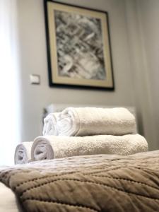 una pila de toallas sentadas encima de una cama en Xenia_Apartments A6, en Kozani