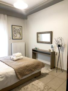 1 dormitorio con cama y espejo en la pared en Xenia_Apartments A6, en Kozani