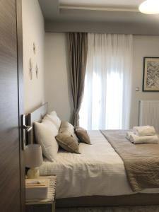 1 dormitorio con 1 cama grande y ventana en Xenia_Apartments A6, en Kozani