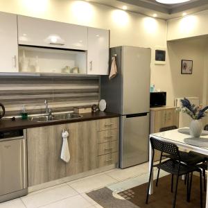 cocina con nevera de acero inoxidable y mesa en Xenia_Apartments A6, en Kozani