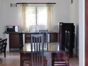 a kitchen with a glass table and a refrigerator at Amssler Beach Stay in Kalutara