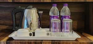 uma bandeja com garrafas e chávenas e uma chaleira. em Hotel City Palace em Varanasi