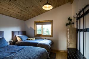 a bedroom with two beds and a window at Fern Lodge - 2 Bedroom Log Cabin - Saint Florence - Tenby in Saint Florence