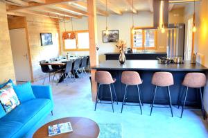 ein Wohnzimmer mit einer blauen Couch und eine Küche in der Unterkunft Chalet 800 in 