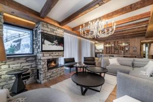 a living room with a fireplace and a stone wall at Penthouse Best View - Les Chalets COVAREL in Val-d'Isère