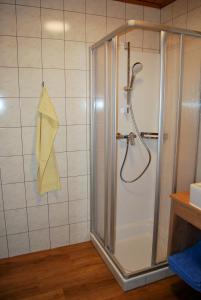 - Baño con ducha y toalla en la pared en Filzmoos Appartements, en Filzmoos