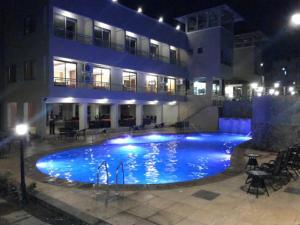 a large swimming pool in front of a building at night at Sukkur Bhavan's SB Resorts & Lawns in Lonavala