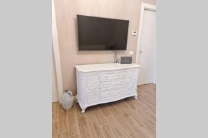 biała komoda z telewizorem z płaskim ekranem na ścianie w obiekcie Maison Marina_Pavia San Michele Centro Storico w mieście Pawia