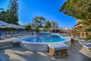 uma grande piscina com cadeiras em Cornucopia Hotel em Xaghra