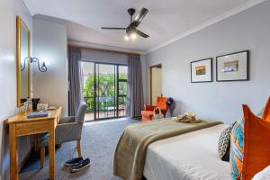 a bedroom with a bed and a desk and a window at Cavern Resort & Spa in Bergville