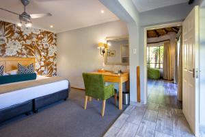 a bedroom with a bed and a desk in a room at Cavern Resort & Spa in Bergville