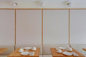 a dining room with two tables with plates and glasses at Badon Boutique Hotel in Saint-Émilion