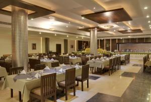 Un comedor con mesas y sillas en un edificio. en Inder Residency Resort & Spa Udaipur, en Udaipur