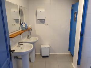ein Badezimmer mit zwei Waschbecken, einem Spiegel und einem WC in der Unterkunft Albergue Villares de Orbigo in Villares de Órbigo