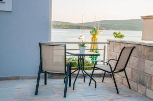 a table and chairs on a balcony with a view of the water at Beach Apartments in Tivat