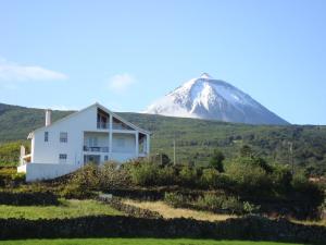 a house in front of a snow covered mountain at Casa Do Canto in São Roque do Pico