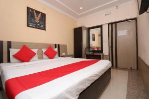 a bedroom with a large bed with red pillows at Central Hotel in Lucknow +26 photos