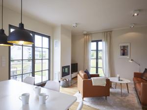 德蘭斯克的住宿－Reetland am Meer - Premium Reetdachvilla mit 3 Schlafzimmern, Sauna und Kamin E16，客厅配有沙发和桌子