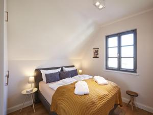 Tempat tidur dalam kamar di Reetland am Meer - Premium Reetdachvilla mit 3 Schlafzimmern, Sauna und Kamin E16