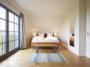 A bed or beds in a room at Reetland am Meer - Premium Reetdachvilla mit 3 Schlafzimmern, Sauna und Kamin E19