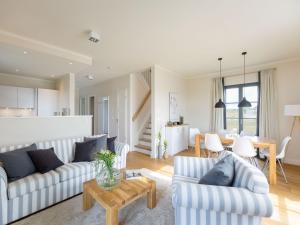 ein Wohnzimmer mit 2 Sofas und einem Tisch in der Unterkunft Reetland am Meer - Premium Reetdachvilla mit 3 Schlafzimmern, Sauna und Kamin E08 in Dranske