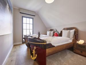 1 dormitorio con 2 camas en un ático en Reetland am Meer - Luxus Reetdachvilla mit 3 Schlafzimmern, Sauna und Kamin E27, en Dranske