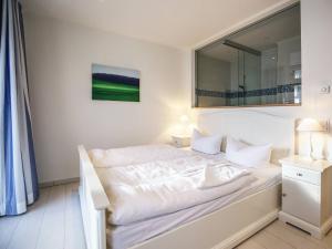 a white bed in a room with a mirror at Strandvillen Binz - Ferienwohnung mit Meerblick, 2 Schlafzimmern und Balkon SV-008 in Binz